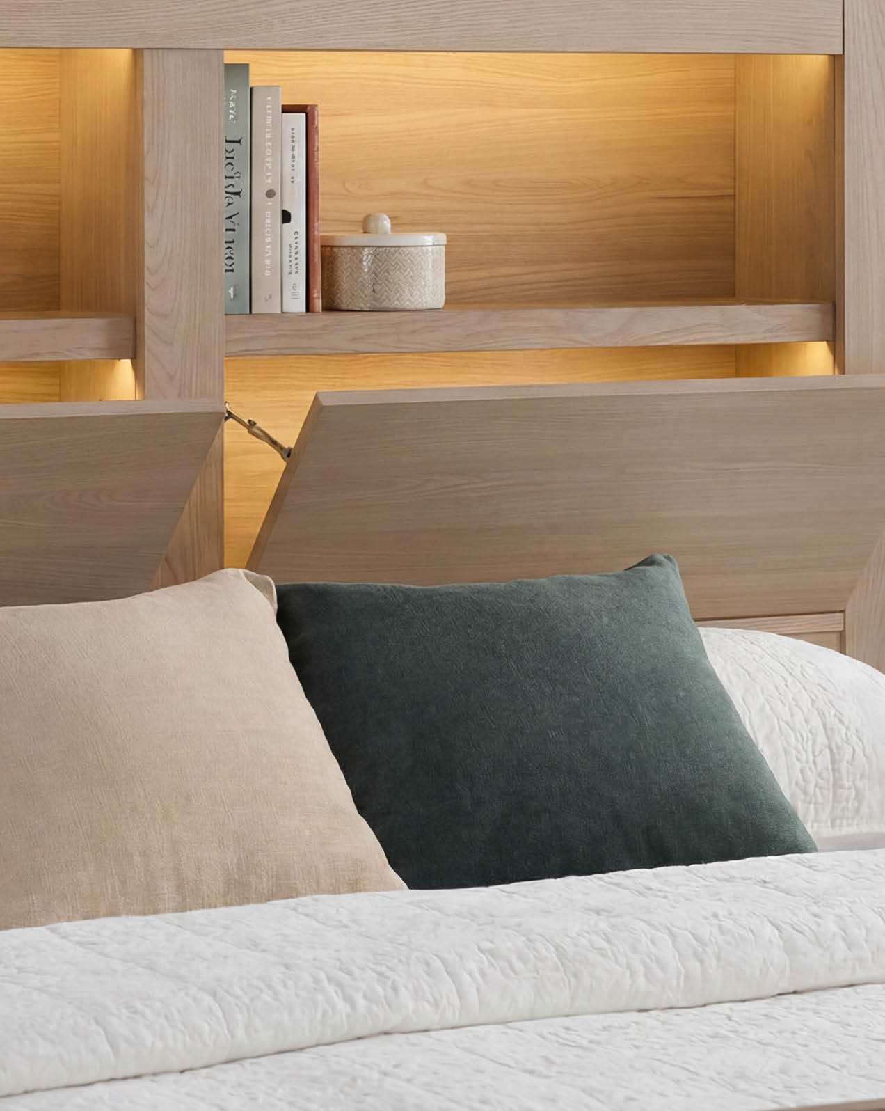 Close-up of Tivoli bed headboard shelving with integrated ambient lighting and decorative accessories.