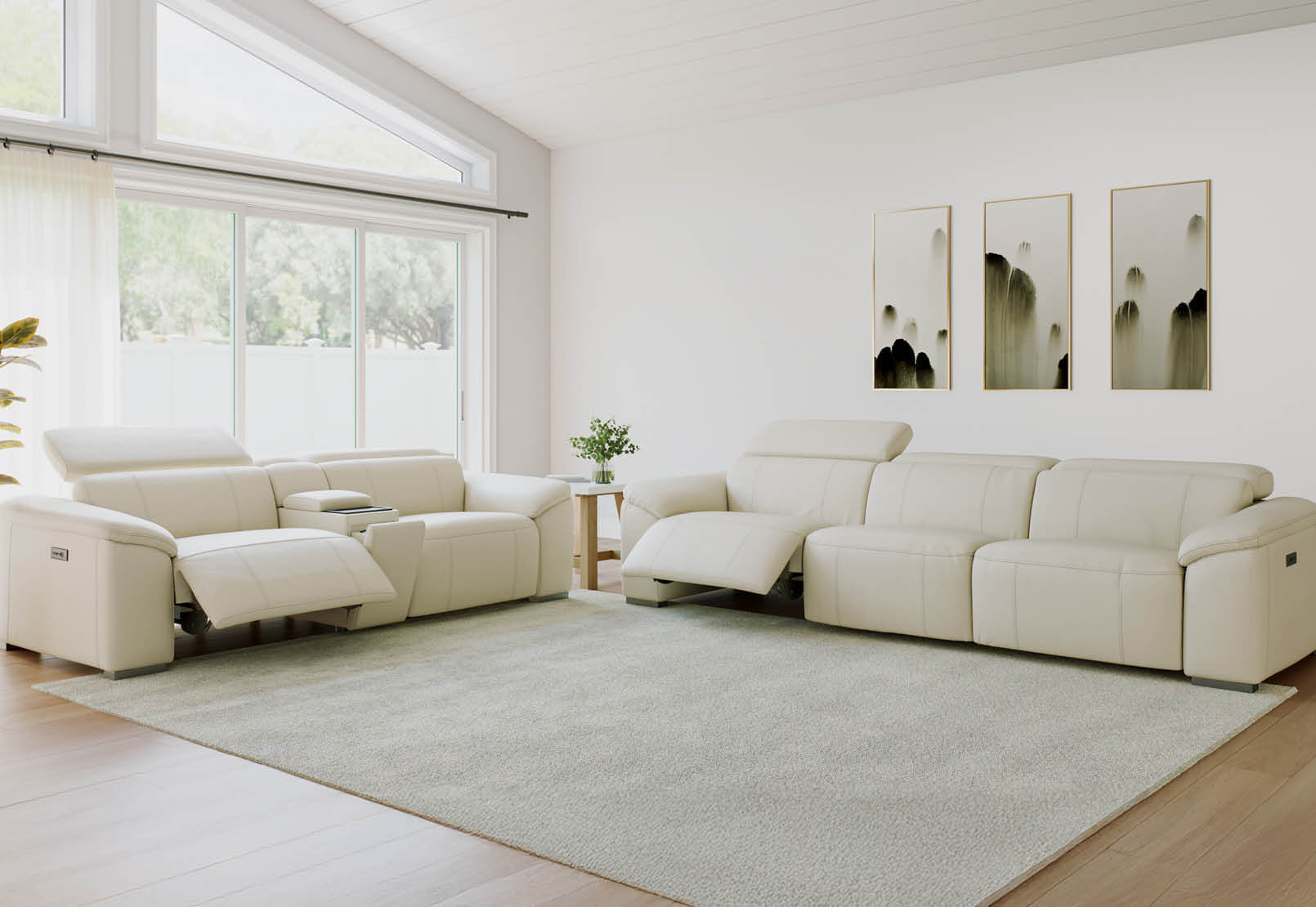 Modern living room featuring the Fiorella 2- and 3-seater recliner sofas in beige leather, arranged with a matching ottoman and soft grey rug under natural light.